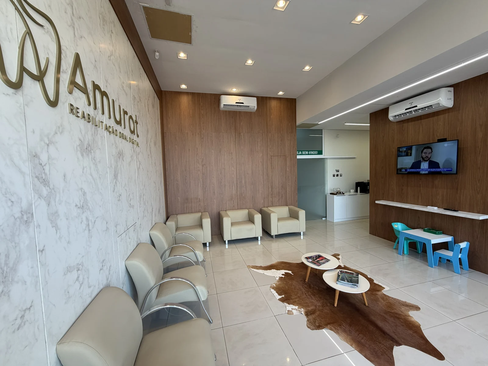 Ambiente amplo da Clínica Amurat com cantinho infantil e TV